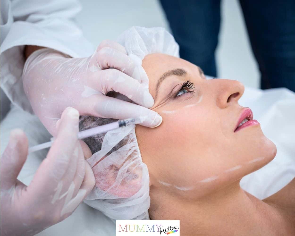 Woman with marked face receiving botox injection