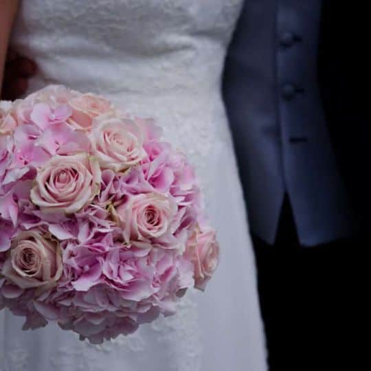 a bride and groom holding a bouquet of flowers
