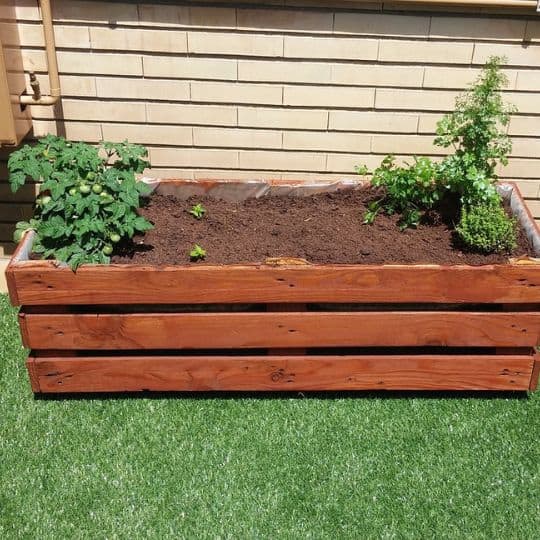 a wooden box with plants in it