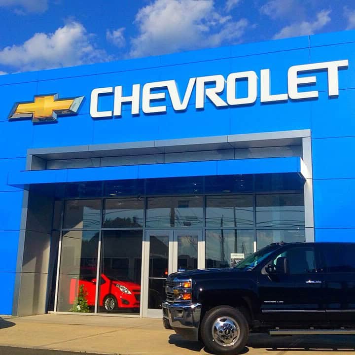 a black truck parked in front of a blue building