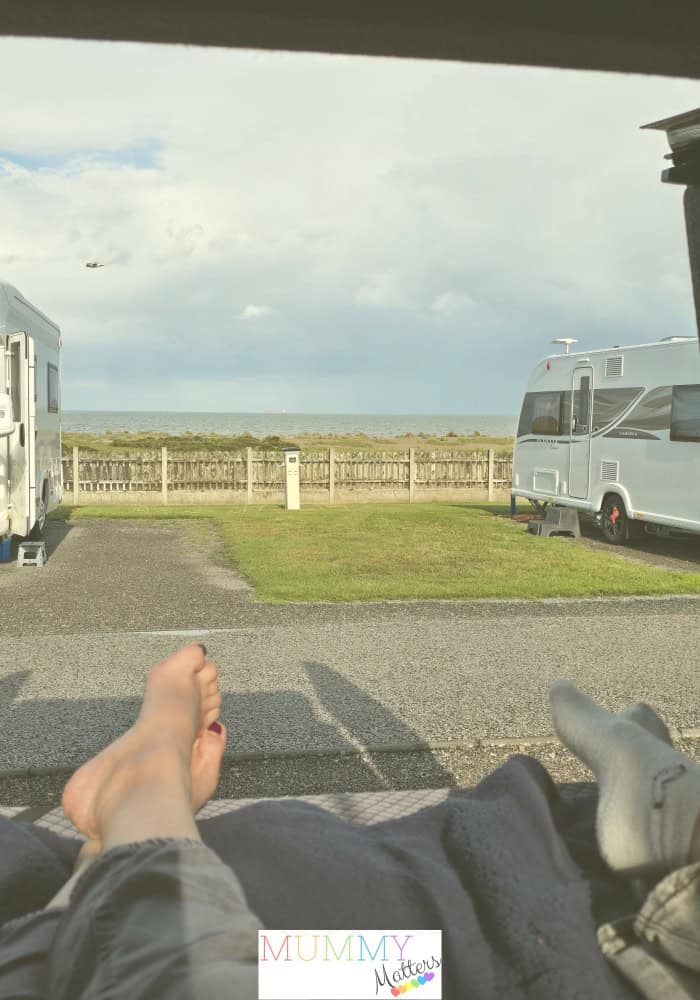 View of the sea from the inside the back of the campervan