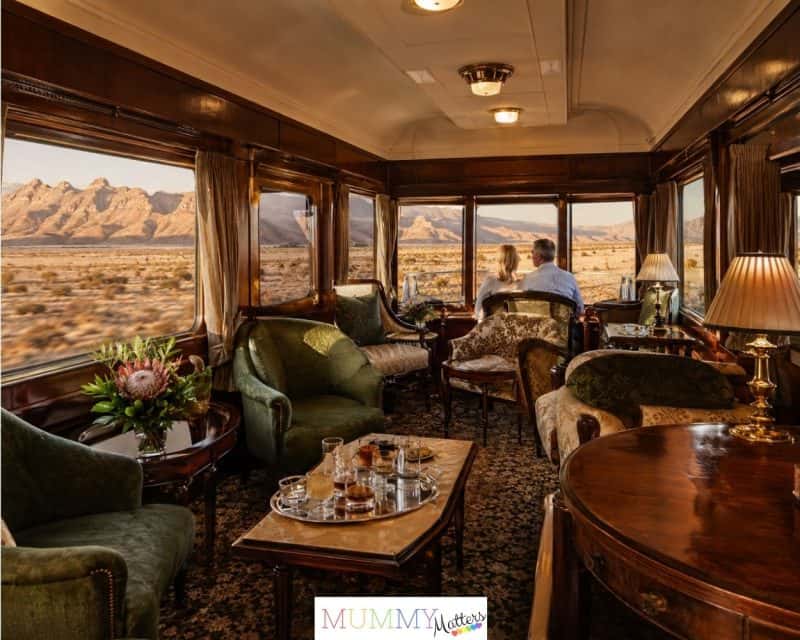 Couple enjoying views of the Karoo from inside a vintage South African luxury train