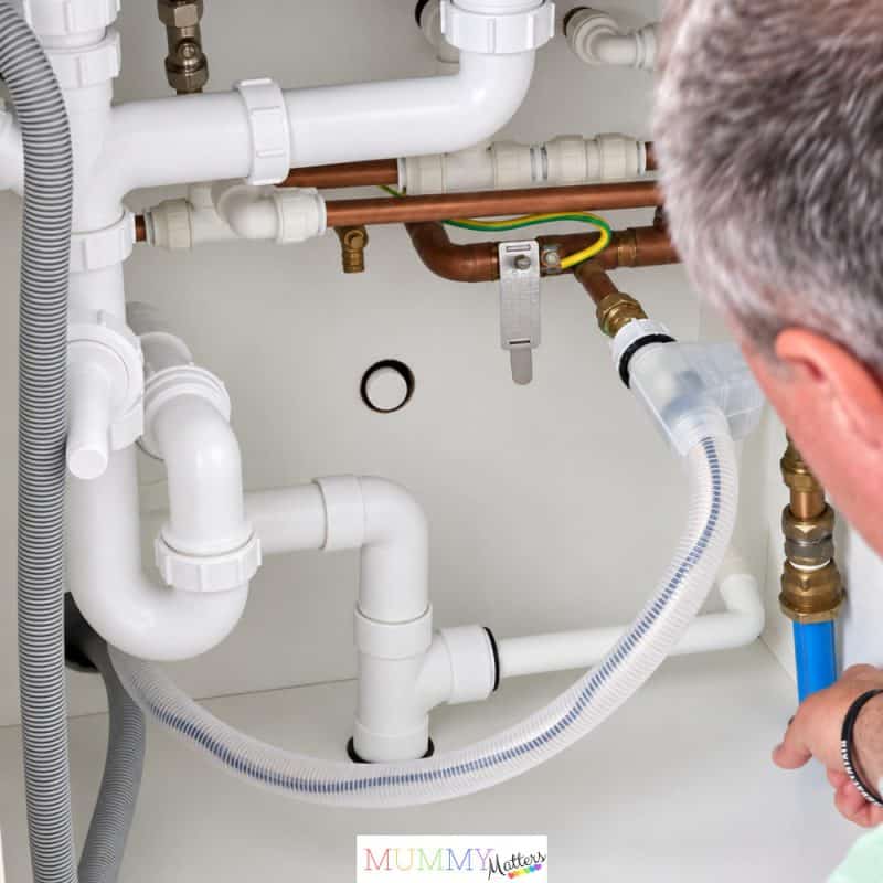 Simon installing the Aquaphor RO-101S reverse osmosis system under our kitchen sink