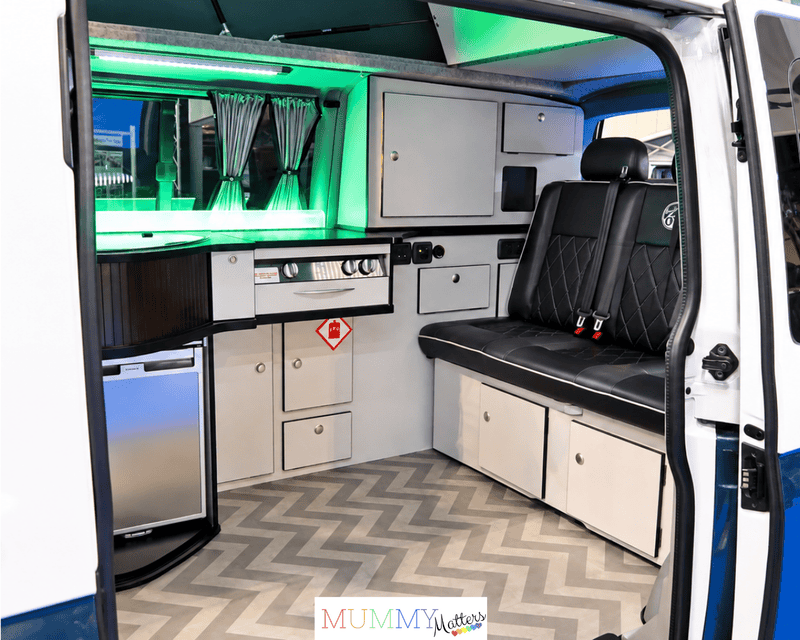 Organised campervan interior with comfortable seating and clever storage for a family road trip.