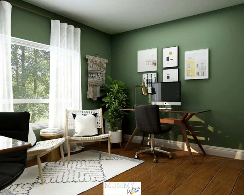 A home office with a wooden desk, black chair, and green walls