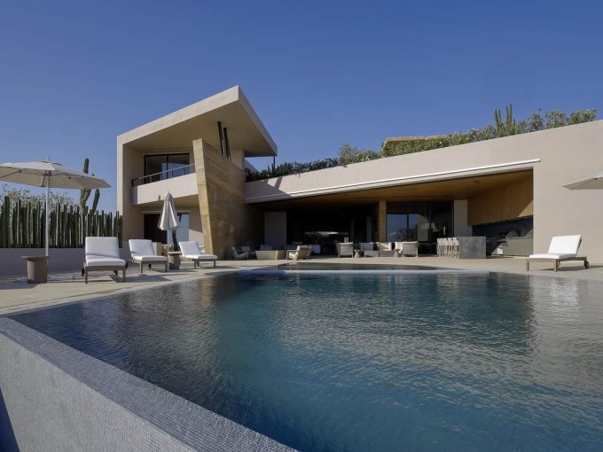 Modern Luxury Villa With A Private Pool In Diamante Cabo San Lucas, Featuring Sleek Architecture, Outdoor Lounge Areas, And Desert Landscaping, Perfect For Upscale Living And Vacation Rentals.