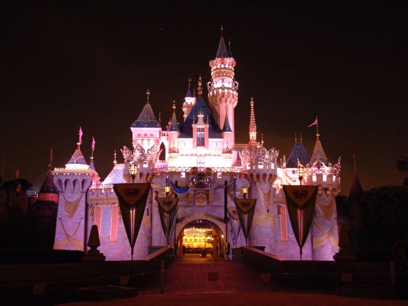 Disneyland castle lit up at night.