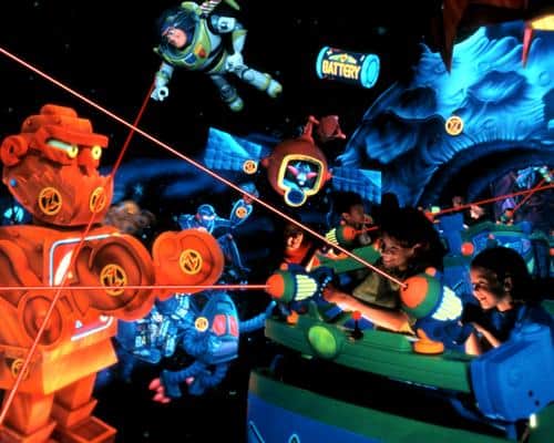 Guests on Buzz Lightyear Astro Blasters at Disneyland fire laser blasters at glowing robots and targets in a galactic atmosphere.
