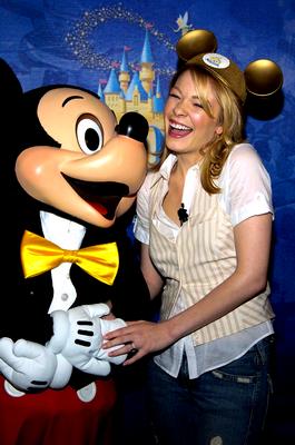 A guest in Mickey Mouse ears beams beside Mickey Mouse himself at Disney World, capturing the pure magic and fun of the park.