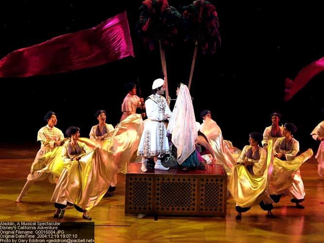 Aladdin and Jasmine dazzle center stage at Disney California Adventure, surrounded by gold-clad dancers in "Aladdin: A Musical Spectacular.