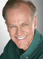 A smiling man in a green shirt.