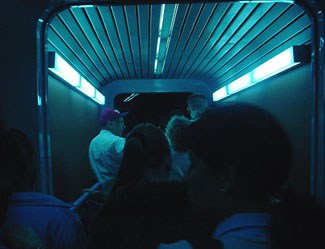 Guests stroll through Tomorrowland’s blue-lit, metallic corridor, immersed in its signature futuristic theme park atmosphere.