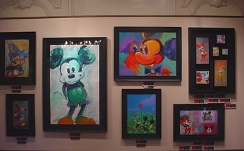 Vibrant framed Mickey Mouse artwork lines a gallery wall in New Orleans Square at Disneyland, perfect for Disney fans.