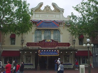 The Walt Disney Story on Main Street, U.S.A. features festive patriotic bunting as guests enjoy a stroll outside the iconic building.