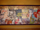 A wall display of classic Disney attraction posters and vintage film ads, framed in wood, evoking theme park nostalgia.