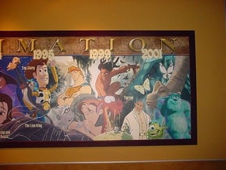 Framed artwork displays classic Disney and Pixar characters from the '90s and 2000s, perfect for any fan’s Disney collection.