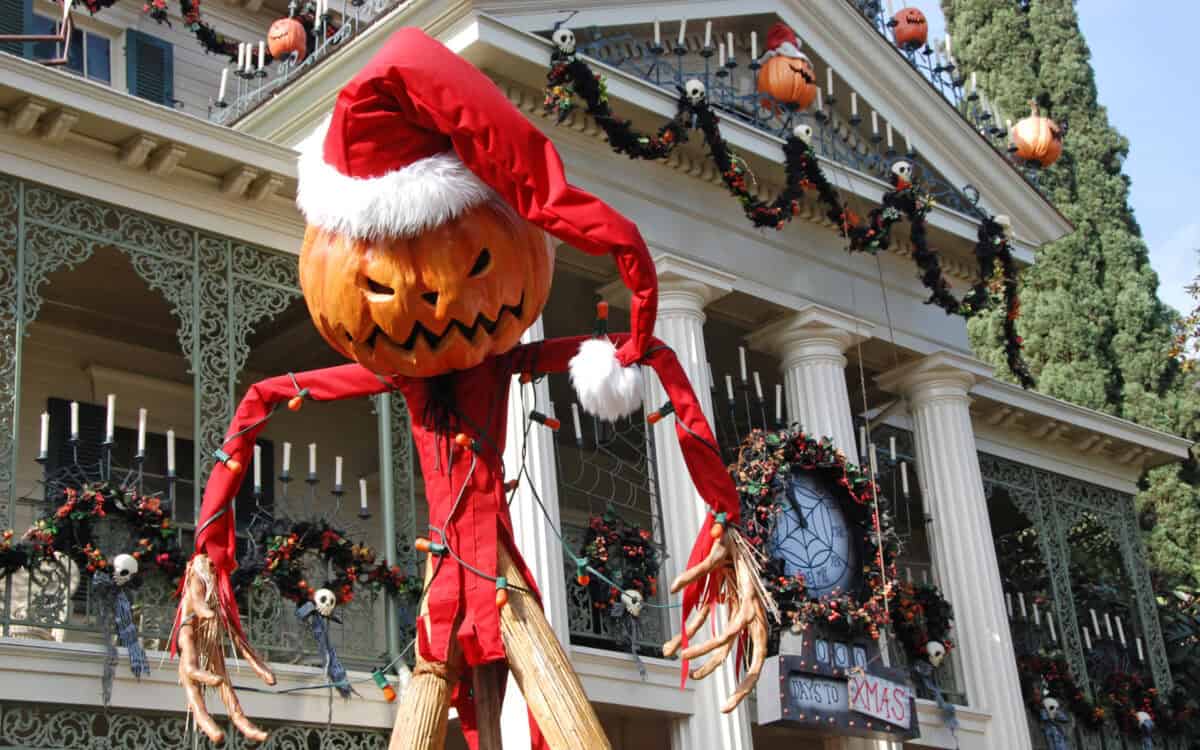 Jack Skellington in a Santa hat towers before Haunted Mansion Holiday at Disneyland, blending Christmas magic with spooky fun.