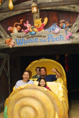 Guests pose for a cheerful photo while riding The Many Adventures of Winnie the Pooh in Critter Country at Disneyland.