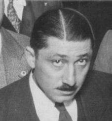 Classic black and white image of Walt Disney, dressed in a suit, gazing upward with an adventurous spirit.