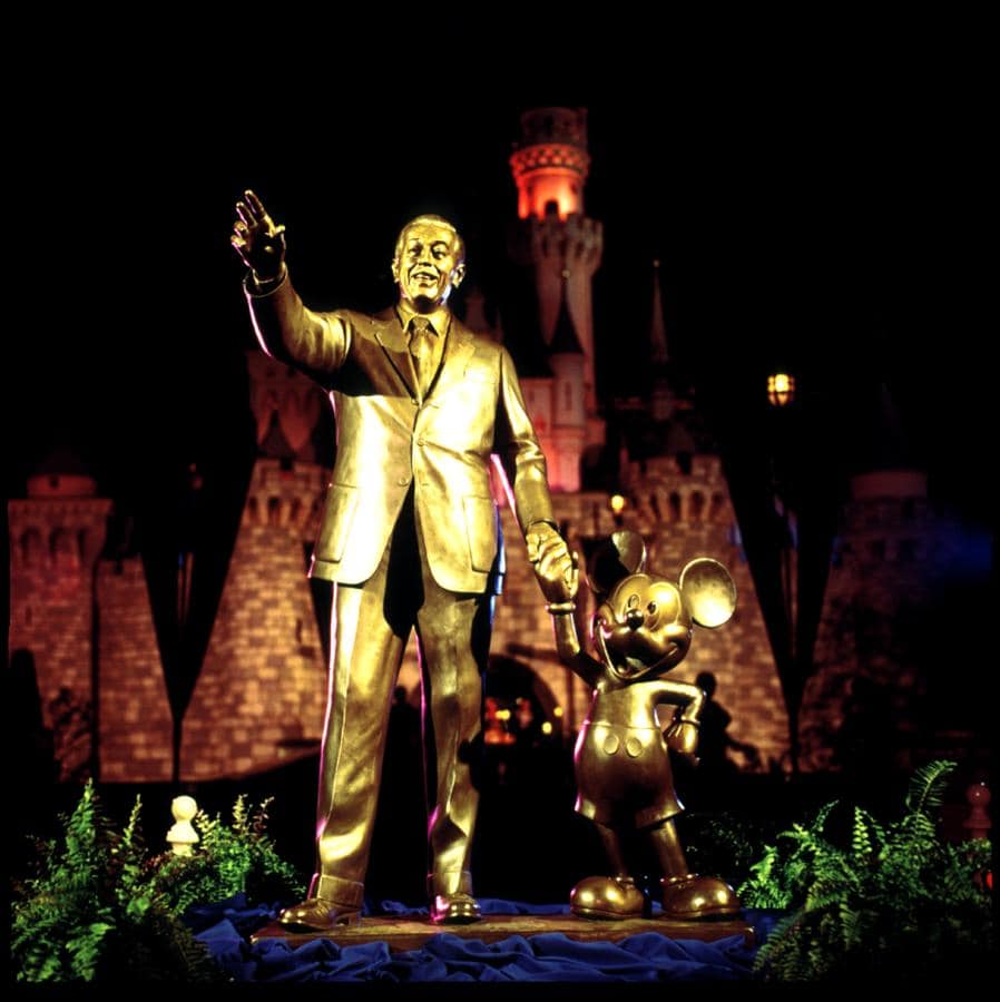 Walt and Mickey’s Partner Statue gleams before Sleeping Beauty Castle, a magical Disneyland nighttime photo spot for every fan.