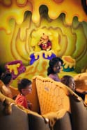 Guests enjoy The Many Adventures of Winnie the Pooh ride in Critter Country, surrounded by whimsical honey-themed décor at Disneyland.