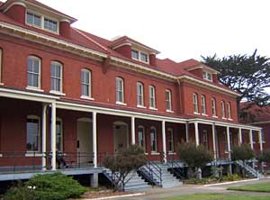 A grand red-brick building with white trim and tall windows, styled like Main Street’s classic architecture at Disney parks.