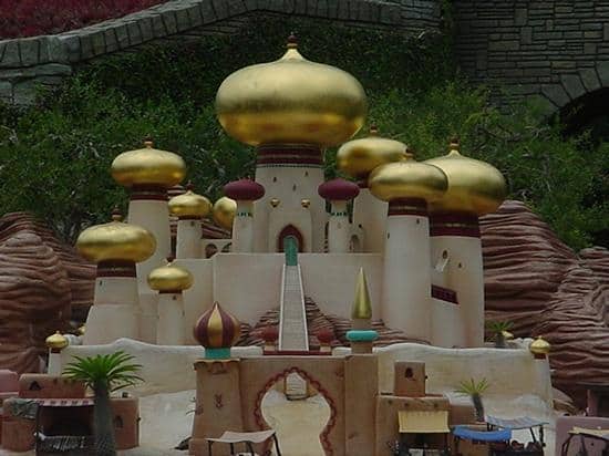 A fantasy palace with shimmering golden domes and arches, set amid trees and red rocks, straight from Storybook Land Canal Boats.