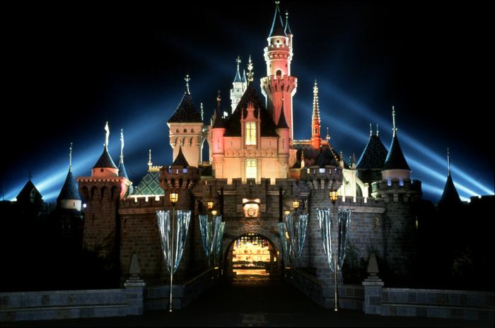 Sleeping Beauty Castle glowing at night with dramatic spotlights—a must-see moment for any Disneyland fan!.