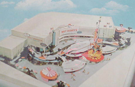 Aerial view of Disneyland in 1955, with vibrant rides and the iconic "Walt Disney's" building welcoming excited guests.