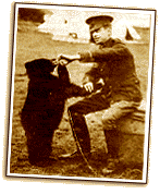 A uniformed soldier feeds a bear cub beside canvas tents, bringing the heartwarming Winnie the Pooh origin story outdoors.