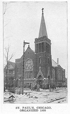 Black-and-white photo of St. Paul's Church in Chicago, organized in 1899. The Gothic-style building features a tall, pointed steeple and arched windows with intricate tracery. People are standing on the snow-covered ground in front of the entrance.