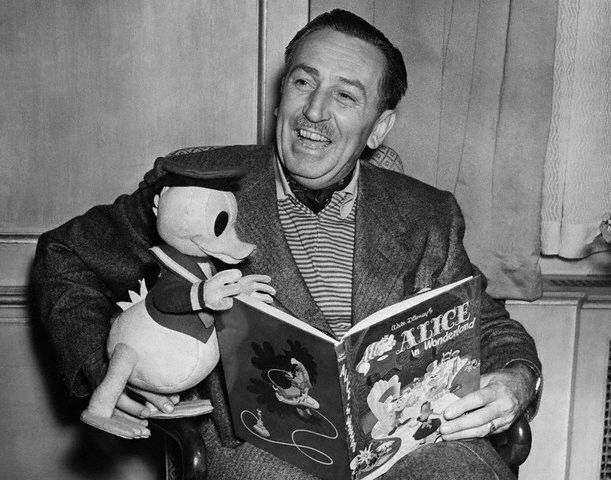 Walt Disney beams with joy, holding a Donald Duck plush and "Alice in Wonderland" book—timeless Disney magic on display.