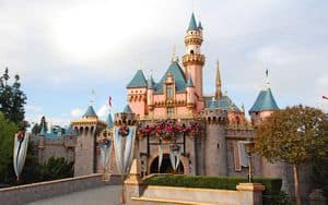 Sleeping Beauty Castle at Disneyland, with iconic blue spires and pink walls beneath a dreamy sky—a must-see for Disney fans.