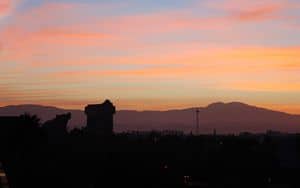 Vibrant sunset over magical park skylines, with glowing rides and iconic architecture creating a dazzling evening backdrop.