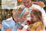 Cinderella and Prince Charming greet a young guest in a yellow dress at Disney, as visitors snap photos of the fairy-tale moment.