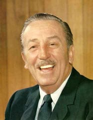 A cheerful man in a suit and tie stands before a wooden backdrop, channeling the visionary spirit of Walt Disney himself.