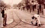 Two Disney Imagineers inspect quiet tram tracks, echoing vintage Disney moments on a peaceful Main Street.
