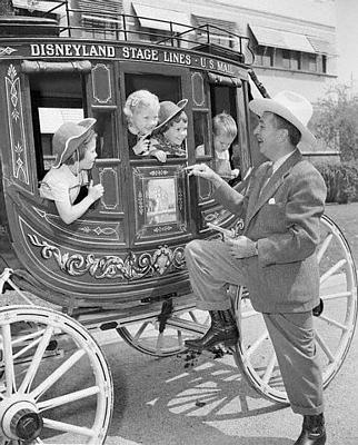 Walt Disney greets excited kids aboard the iconic Disneyland U.S. Mail stagecoach under clear, sunny skies.