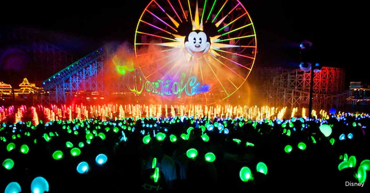 Nighttime water and light spectacular at Disney California Adventure, featuring the Mickey’s Fun Wheel and glowing ear hats in the audience.