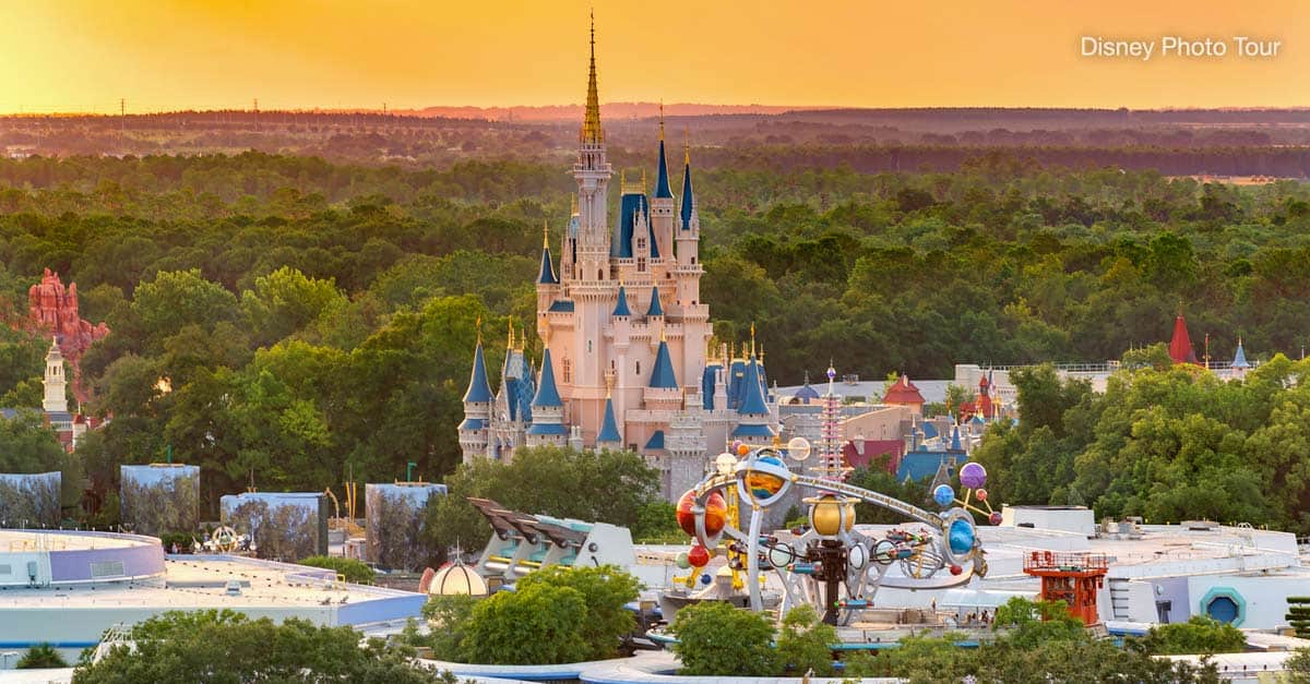 Cinderella Castle glowing at sunset in Magic Kingdom, framed by lush trees and nearby attractions in the heart of Disney World.