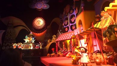 It's a Small World" attraction featuring lively dolls, a radiant sun, and dazzling global decor in a whimsical Disney setting.