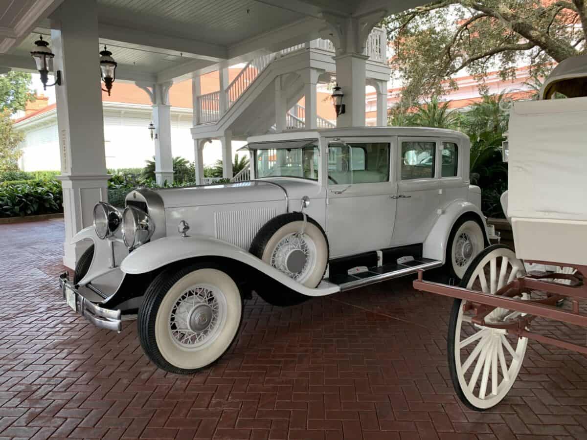 A vintage white car and white wagon parked at the Grand Floridian, capturing Disney’s signature elegance and charm.