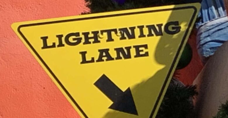Lightning Lane yellow triangle sign with black arrow, pointing Disneyland fans to their next Genie+ adventure.