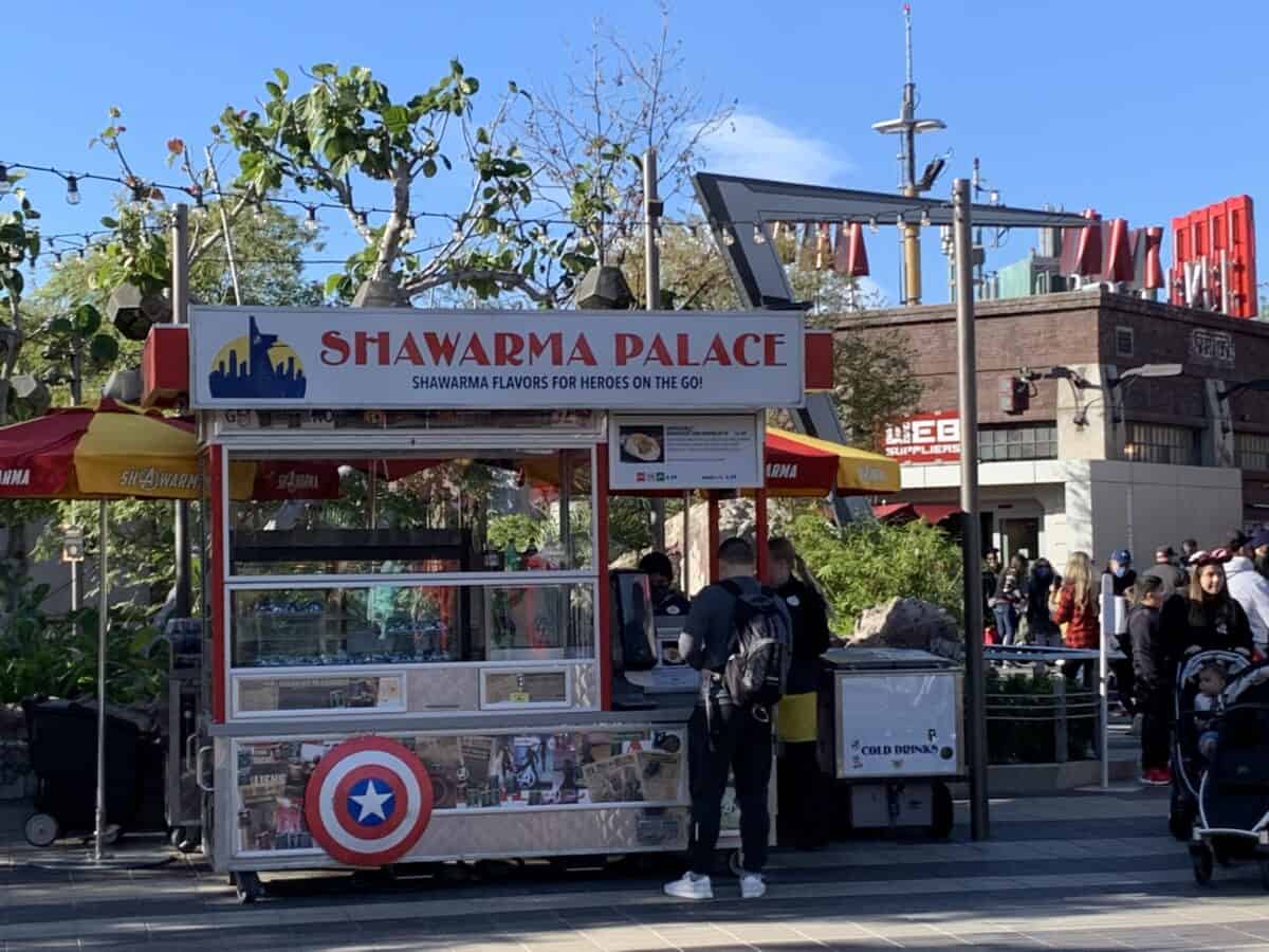 Shawarma Palace cart featuring a Captain America shield at Avengers Campus, surrounded by crowds enjoying Disneyland excitement.
