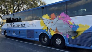 A vibrant Mears Connect bus sporting Orlando Airport & Resorts art, ready to whisk guests to theme parks and resorts.