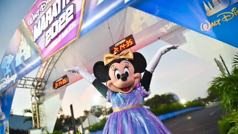 Minnie Mouse dazzles in a purple dress at the Walt Disney Marathon 2022 finish, cheering with athletes and Dopey runners.