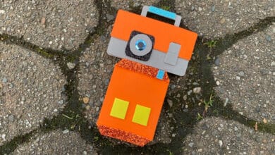 A playful robot made from vibrant foam pieces, resembling a fun arts-and-crafts activity on a theme park’s decorative walkway.