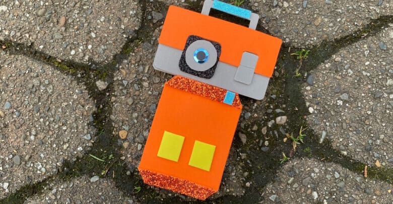 A playful robot made from vibrant foam pieces, resembling a fun arts-and-crafts activity on a theme park’s decorative walkway.