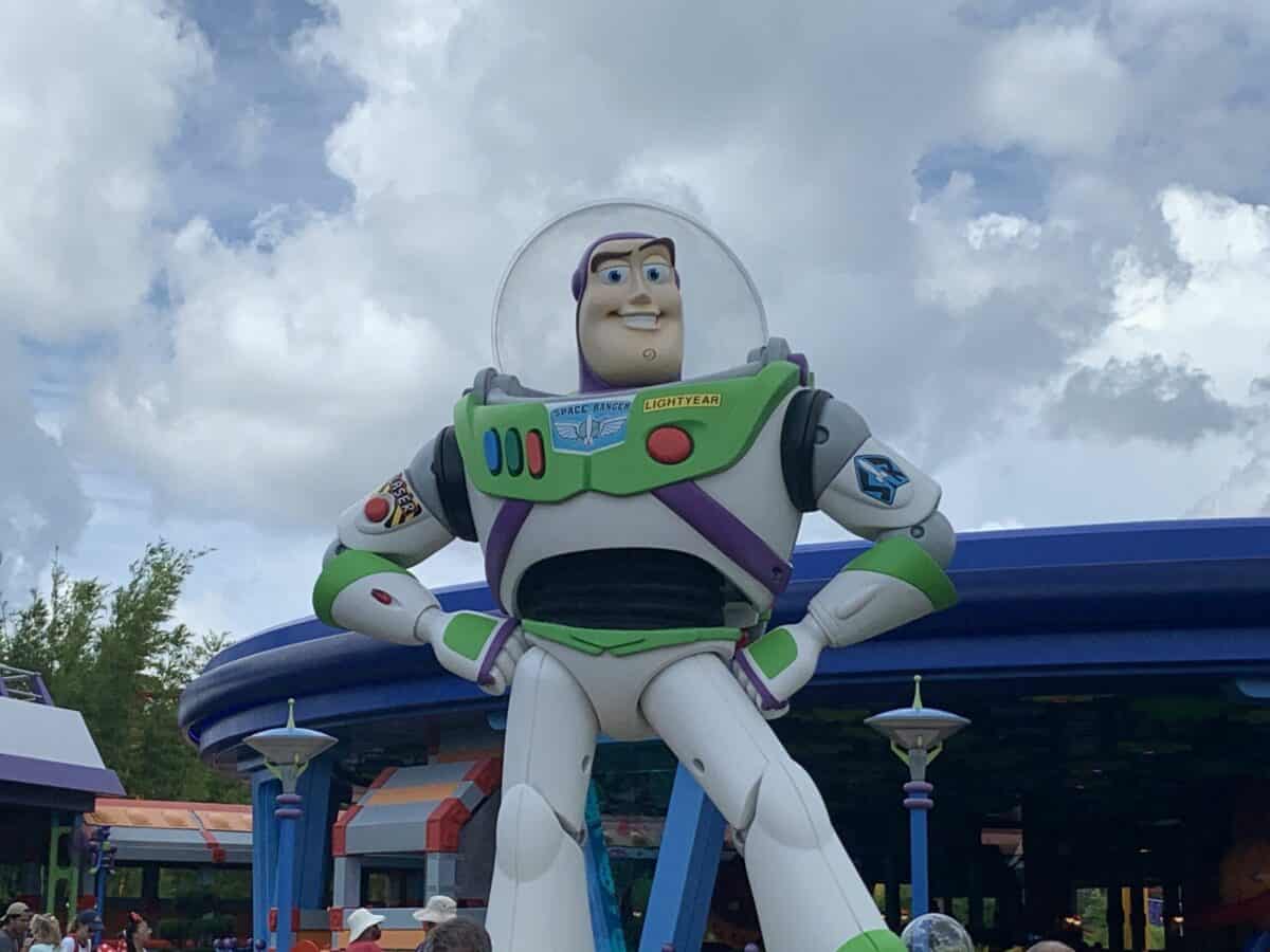 Buzz Lightyear greets fans at Toy Story Land, striking a hero pose beneath cloudy skies and inviting guests to adventure.