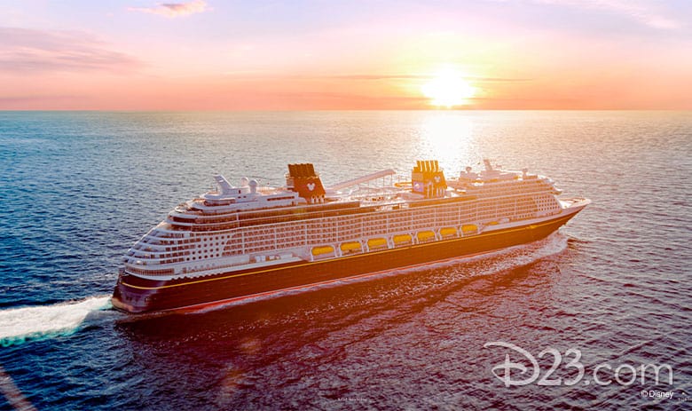 The Disney Wish glides across the ocean at sunset, beneath a vibrant sky, evoking excitement for its magical maiden voyage.